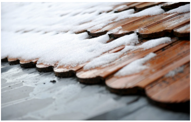 Winter snow accumulation on a residential barrel tile roof.