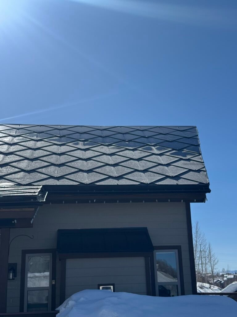 Modern house with a dark blue interlocking solar shingle roof.