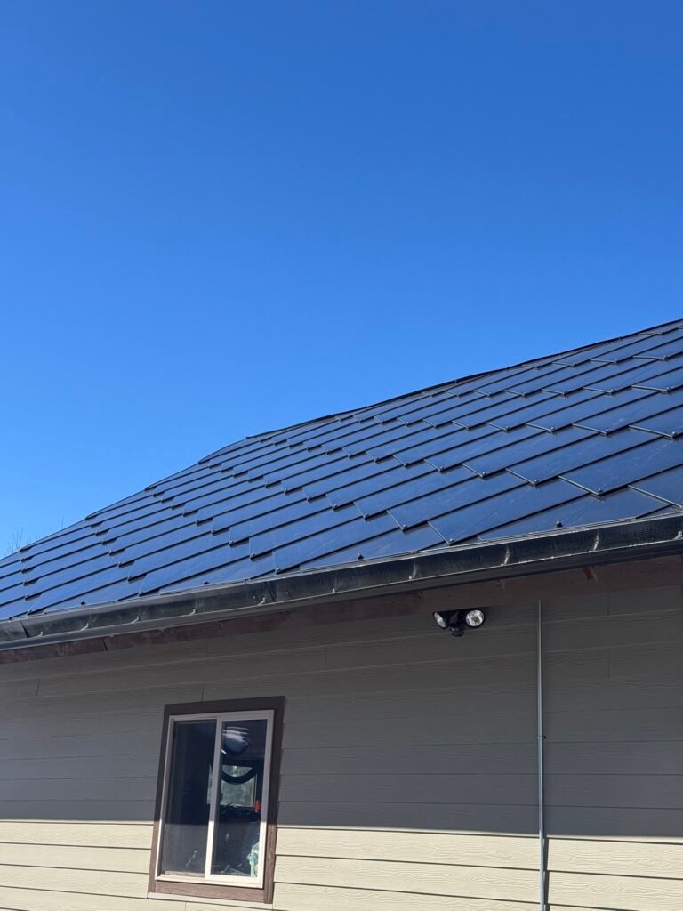 Modern house featuring a dark blue interlocking SunStyle solar shingle roof.