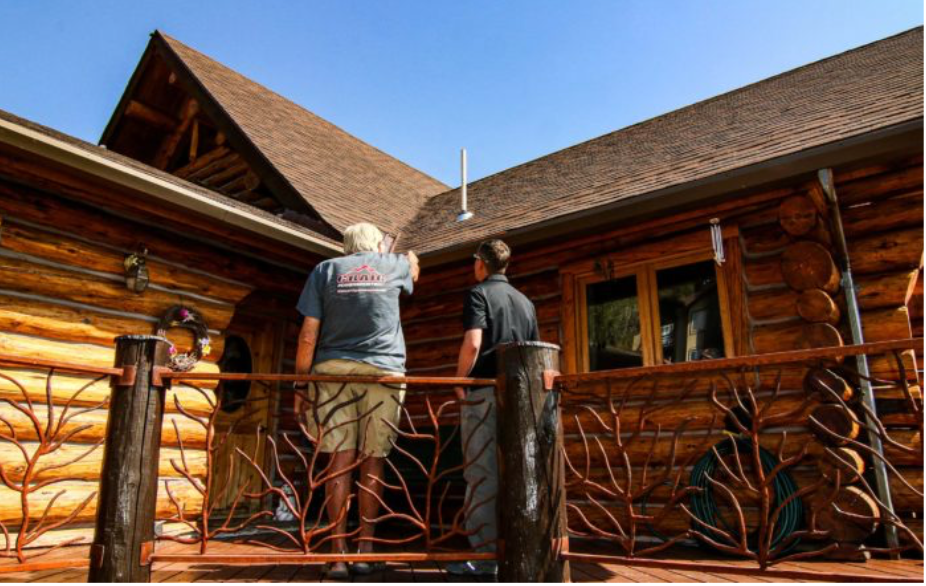 Professional roofing inspection on a residential log home roof.